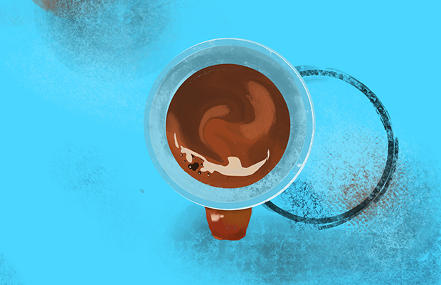 A cup of coffee sits on a table.